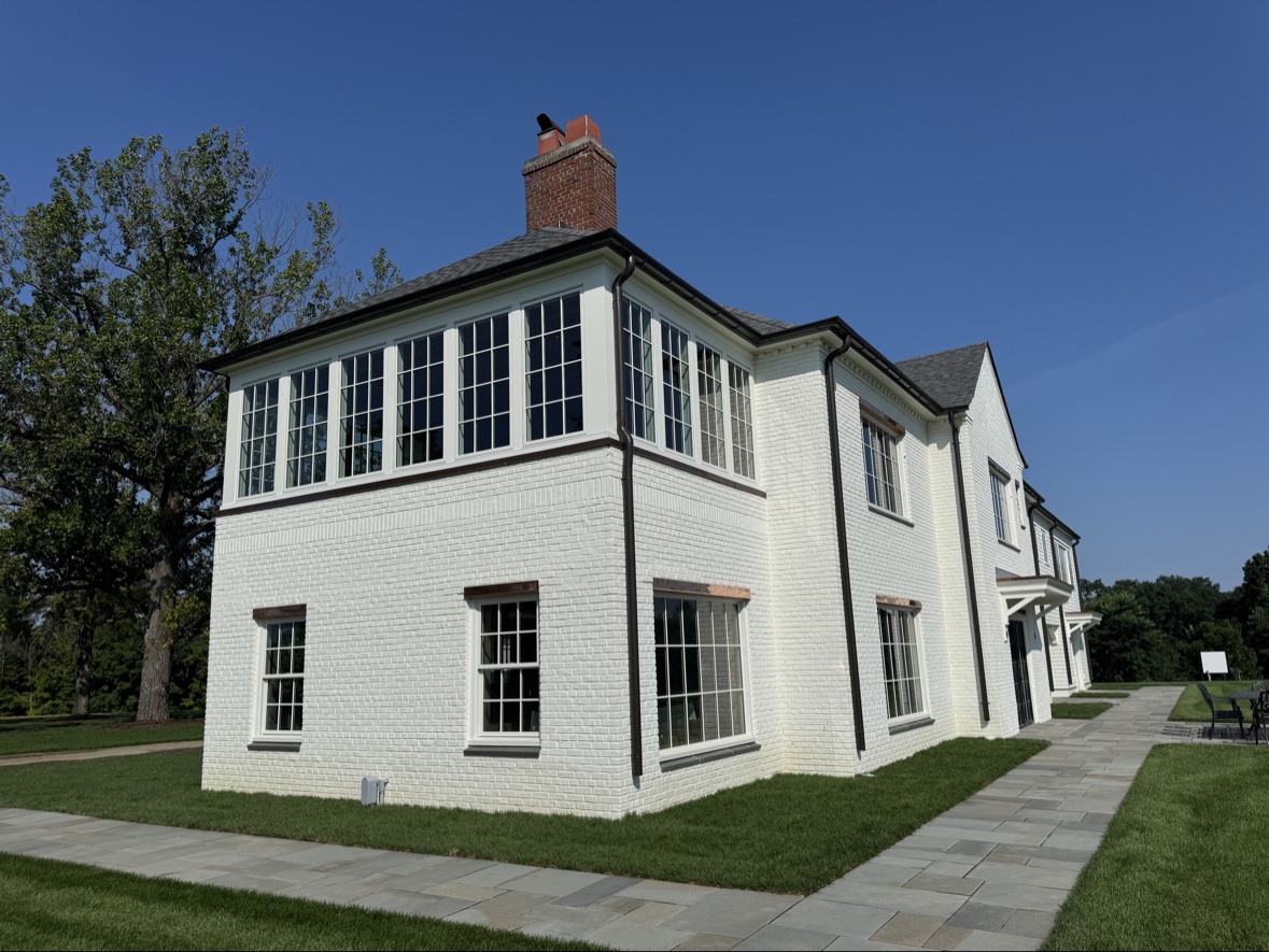White brick home with new black windows in Holmdel NJ by Atlantic Custom Homes
